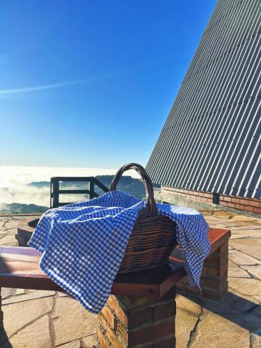 Ein blau-weißer Regenschirm steht auf einer Bank in der Unterkunft Chalés Vista dei Monti in Dois Lajeados