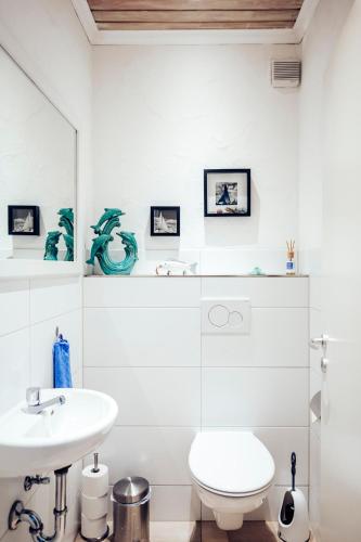a white bathroom with a sink and a toilet at Ferienwohnung Stadtplatz 25 in Traunstein