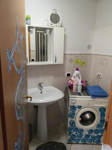 a bathroom with a sink and a washing machine at Little art house in Gaeta