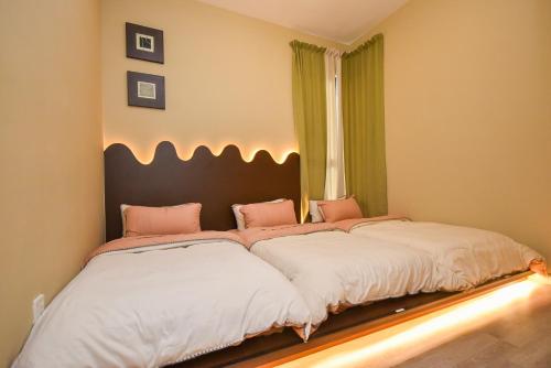 a bedroom with two beds with pink and white sheets at Midvalley Southkey Mosaic Suite by Nest Home in Johor Bahru