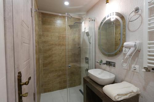 a bathroom with a shower and a sink and a mirror at Palm Tbilisi Boutique Hotel in Tbilisi City