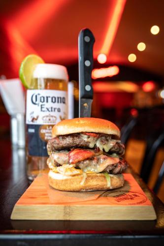 a hamburger on a cutting board next to a bottle of beer at Kildare House Hotel in Kildare