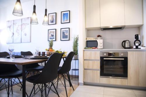 a kitchen and dining room with a table and chairs at Apartment BW Maria Belgrade in Sajmište
