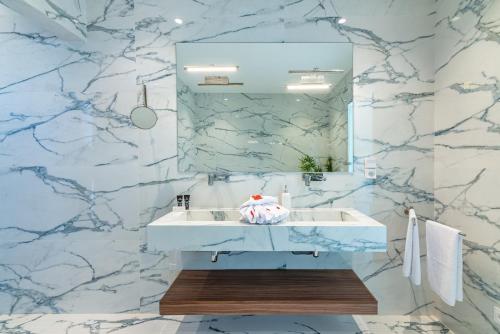 a bathroom with a white sink and a mirror at Villa Elysée - Piscine et jardin Privée Sans vis-à-vis Wifi HD in Sraghna