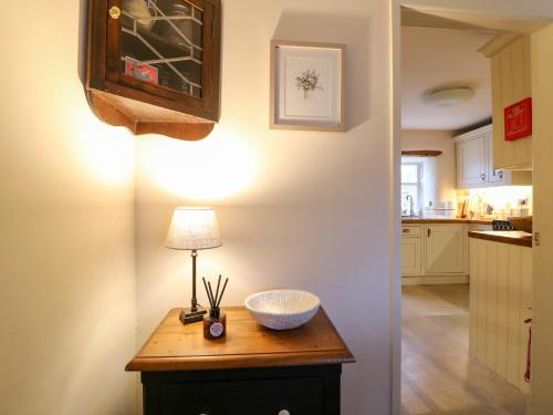 a kitchen with a table with a lamp on it at Rose Cottage in Buxton