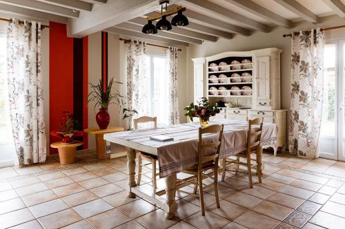 une cuisine avec une table et des chaises dans une pièce dans l'établissement chambres hôte maison florenia, à Caro