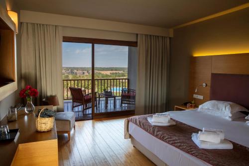 a hotel room with a bed and a balcony at Bakucha Vineyard Hotel ve Spa in Lüleburgaz