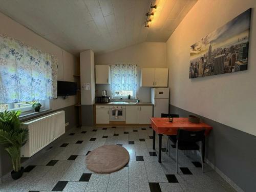 a small room with a table and a kitchen at Möblierte Wohnung für 3 Personen - KMK Monteure in Perl