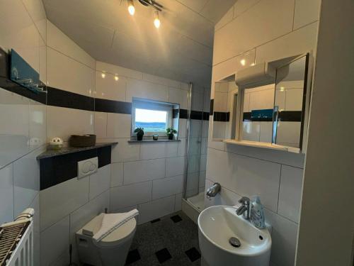 a white bathroom with a sink and a toilet at Möblierte Wohnung für 3 Personen - KMK Monteure in Perl