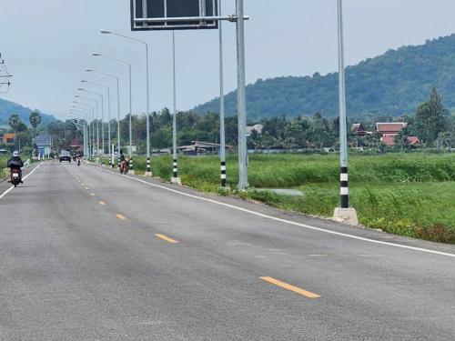a group of motorcycles driving down a road with street lights at Villa Baansiesom in Sam Roi Yot
