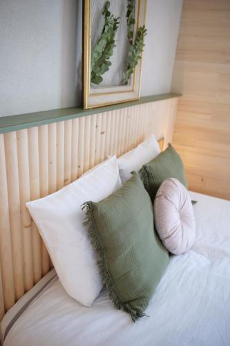 a bed with four pillows and a picture on the wall at Maison Stony - Gîtes & Vignoble in Frontignan