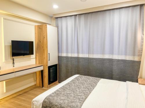 a bedroom with a bed and a flat screen tv at Tophane Mansion Karakoy in Istanbul