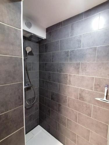 La salle de bains est pourvue d'une douche et d'un mur en carrelage. dans l'établissement Au petit Névé, aux Houches
