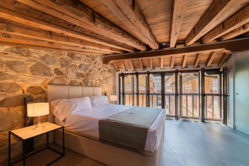 ein Schlafzimmer mit einem Bett und einer Steinwand in der Unterkunft Apartamentos Santa Fe - Calle Armas by Toledo AP in Toledo
