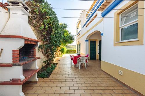 a patio with a table and chairs in a house at Moradia T3 Com Terraço Solarengo in Carrapateira