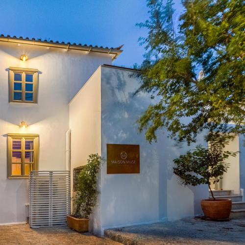 a white house with a sign on the side of it at Maison Muse in Hydra