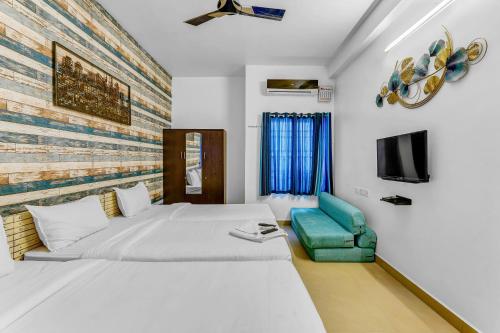 une chambre avec un grand lit et une chaise verte dans l'établissement Inn10 Homestays and Resort, à Chennai