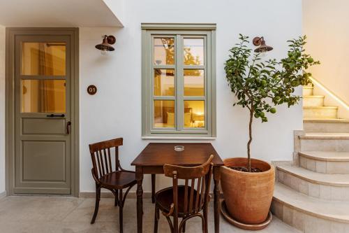 a dining room with a table and a potted tree at Maison Muse in Hydra