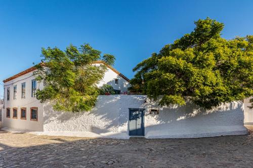a white building with a tree in front of it at Maison Muse in Hydra