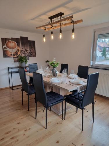 a dining room with a wooden table and chairs at FeWo Lichtblick in Mengen
