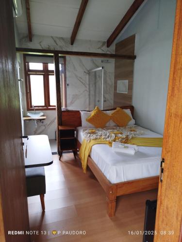 a bedroom with a bed and a desk in a room at Pousada do Altar in Conceição do Mato Dentro