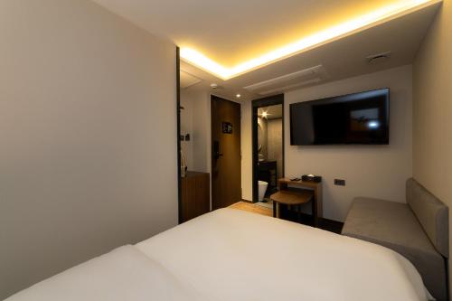 a hotel room with a bed and a couch at Guwol Hotel in Seoul