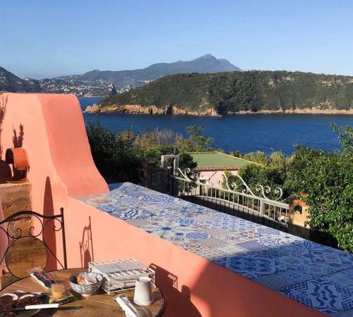 a balcony with a table and a view of a lake at sole chiaro home in Procida