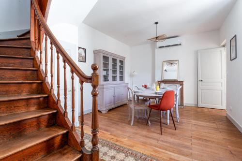 ein Esszimmer mit einem Tisch und einer Treppe in der Unterkunft Maison clim jardin Tours centre 8 personnes 4 chambres in Tours
