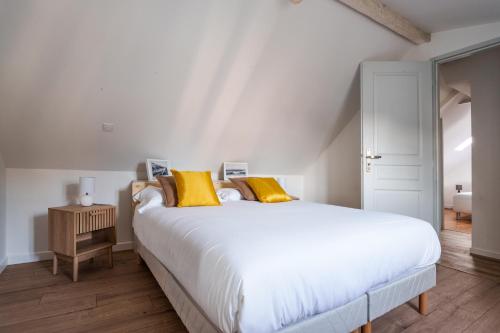 - une chambre avec un grand lit blanc et des oreillers jaunes dans l'établissement Maison clim jardin Tours centre 8 personnes 4 chambres, à Tours