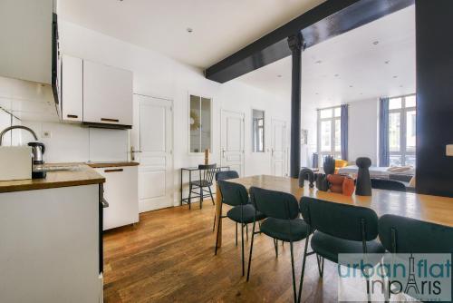 une cuisine et une salle à manger avec une table et des chaises dans l'établissement Urban Flat 34 - Beautiful 3 Bedroom Paris Louvre, à Paris