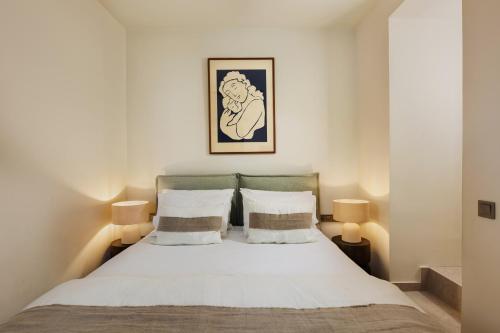a bedroom with a white bed with two lamps at Maison Muse in Hydra