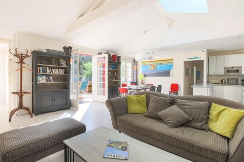 un salon avec un canapé et une cuisine dans l'établissement Maison Serapias - Welkeys, à Dolus-d'Oléron