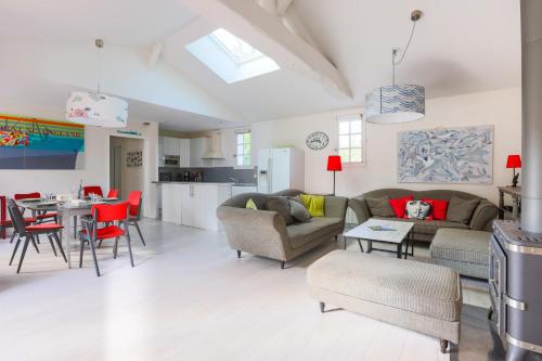 un salon avec un canapé et une table avec des chaises dans l'établissement Maison Serapias - Welkeys, à Dolus-d'Oléron