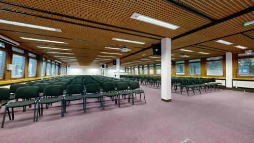 an empty room with green chairs in a building at Yarnfield Park Training And Conference Centre in Stone