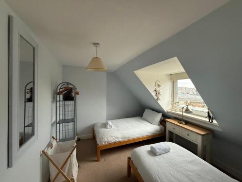 a attic bedroom with a bed and a mirror at Riverside Cottage City Centre in Inverness