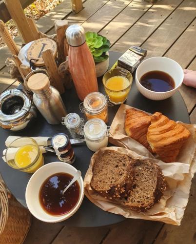 ein Tisch mit Brot und anderen Lebensmitteln darauf in der Unterkunft Cocoon Village in Porto-Vecchio
