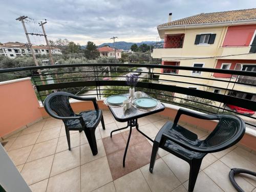 a balcony with a table and chairs on a balcony at Eriand Maisonette in Lefkada Town