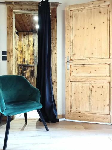 une chaise verte assise devant une porte dans l'établissement Domaine les lodges nature ,private wellness, à Soultzeren