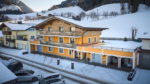 a group of buildings in the snow with cars parked at Haus Miller in Sankt Veit im Pongau