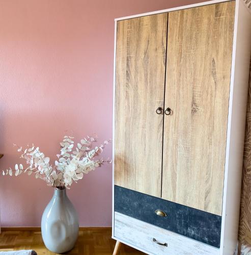 a vase of flowers sitting next to a cabinet at Ferienhaus Auszeit in Grabenstätt