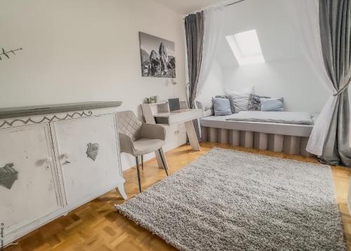 a small room with a bed and a desk and a table at Ferienhaus Auszeit in Grabenstätt