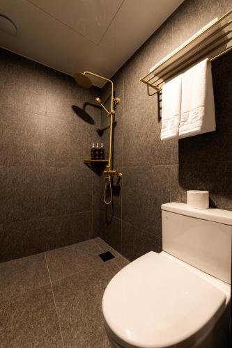 a bathroom with a toilet and a shower at Guwol Hotel in Seoul