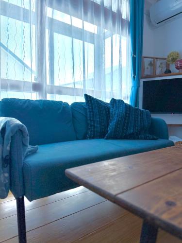 a blue couch in a living room with a table at 蒼穹 in Asahikawa