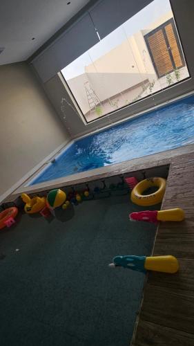 a room with a swimming pool with a window at شاليه اجمل مساء 1 in Al Mālī