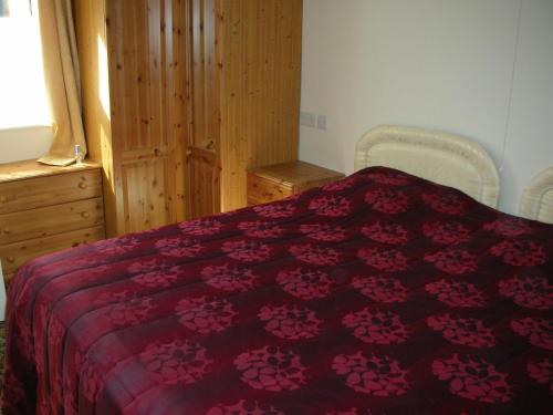 une chambre avec un lit avec une couette rouge dans l'établissement Watermill Farm Cottages, à Metheringham