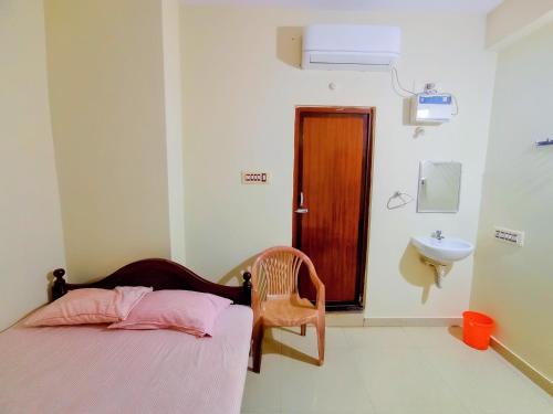 Ahobilam VPS NIVAS Guest House في Pedda Ahobilam: غرفة نوم صغيرة بها سرير ومغسلة