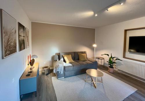 a living room with a couch and a table at Apartment im Naturpark Westensee in Westensee