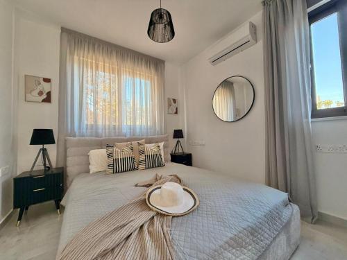 a bedroom with a bed with a hat on it at New Luxury Georgia Beach Villa II in Argaka
