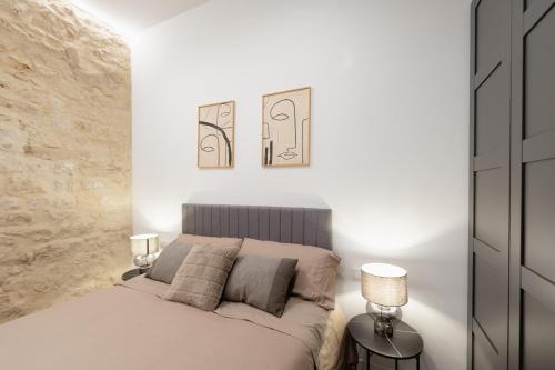 a white bedroom with a bed and two lamps at Apartamento Casa Liam in Alicante