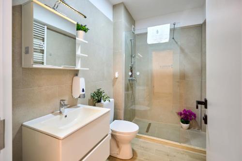 a bathroom with a toilet and a sink and a shower at Nikola Apartment Infinity Resort in Mamaia